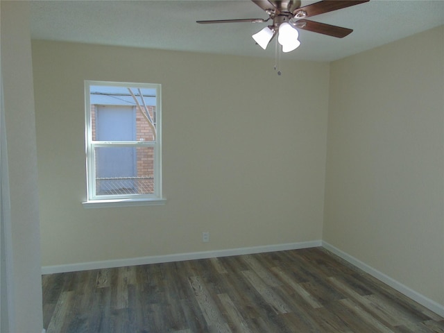 empty room with ceiling fan and dark hardwood / wood-style flooring