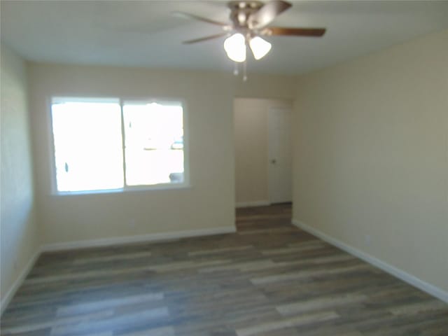 empty room with dark wood-type flooring and ceiling fan