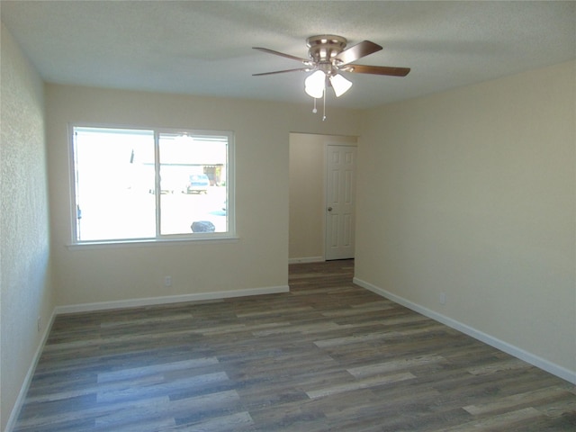 empty room with dark wood-type flooring and ceiling fan