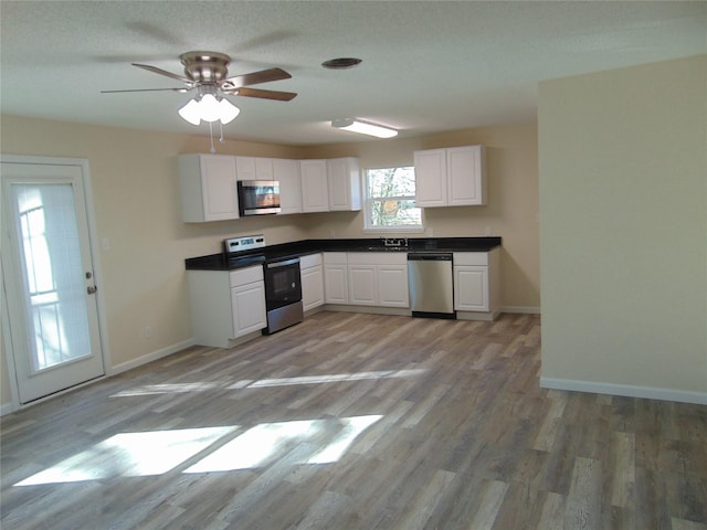 kitchen featuring sink, ceiling fan, appliances with stainless steel finishes, white cabinetry, and light wood-type flooring