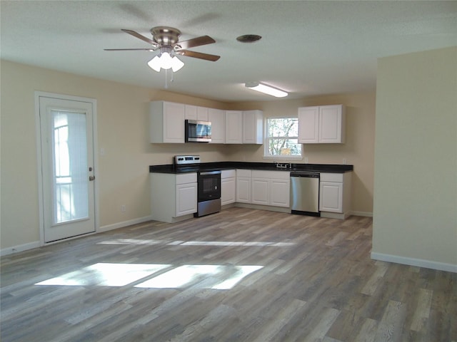 kitchen featuring sink, white cabinetry, light hardwood / wood-style flooring, ceiling fan, and stainless steel appliances