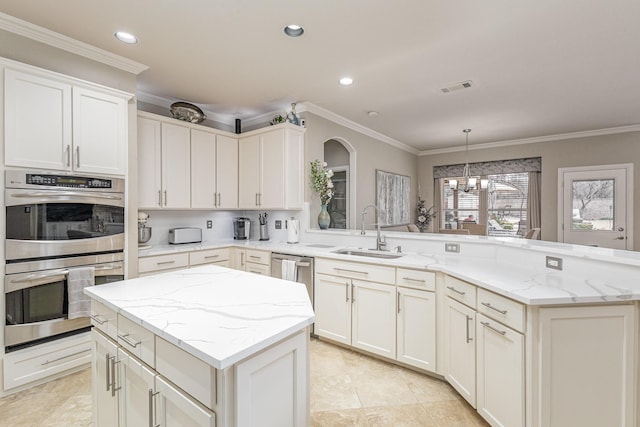 kitchen featuring sink, stainless steel appliances, light stone countertops, decorative light fixtures, and kitchen peninsula