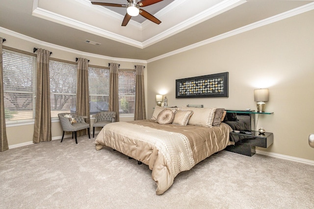 carpeted bedroom featuring multiple windows, ornamental molding, a raised ceiling, and ceiling fan