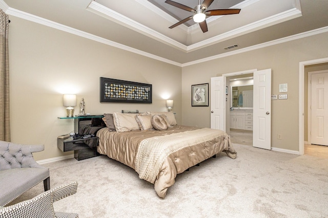 carpeted bedroom featuring a raised ceiling, ornamental molding, connected bathroom, and ceiling fan