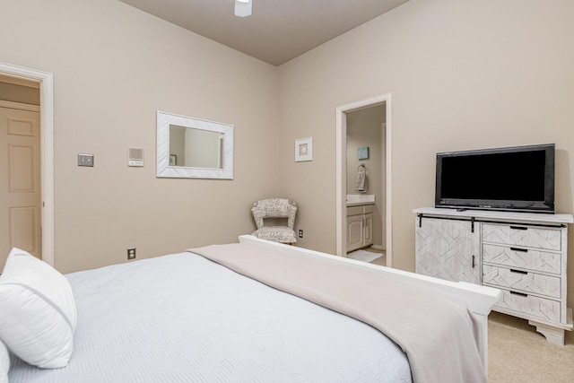 bedroom featuring ensuite bathroom, carpet flooring, and ceiling fan