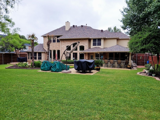 rear view of property featuring a lawn and a patio