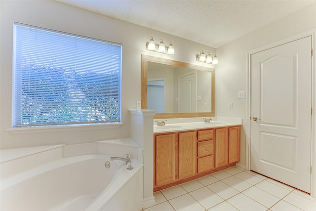 bathroom featuring vanity, tile patterned flooring, a bathing tub, and a textured ceiling