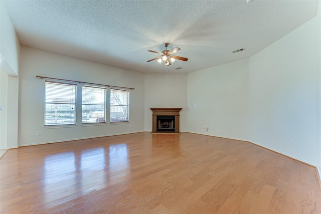 unfurnished living room with light wood-type flooring, a textured ceiling, and ceiling fan