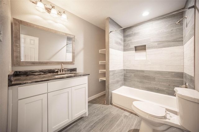 full bathroom with vanity, tiled shower / bath combo, and toilet