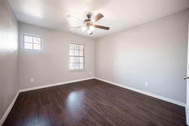 spare room featuring dark wood-type flooring and ceiling fan