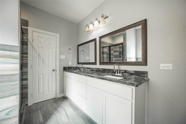 bathroom with walk in shower, vanity, and hardwood / wood-style floors