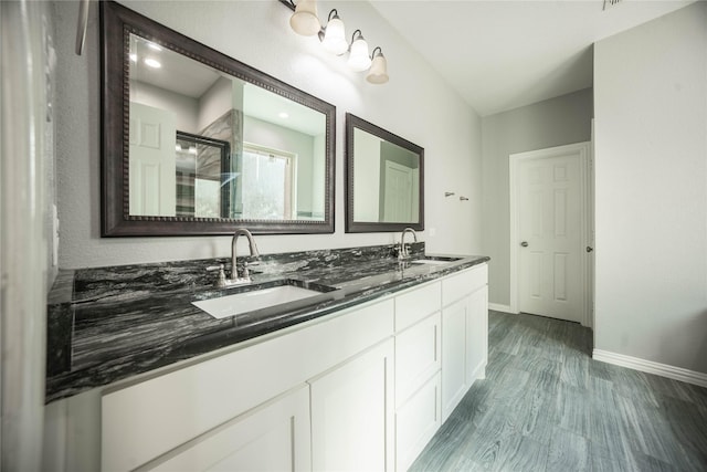 bathroom featuring vanity, hardwood / wood-style flooring, and a shower with door