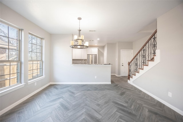 interior space with sink, dark parquet floors, and an inviting chandelier