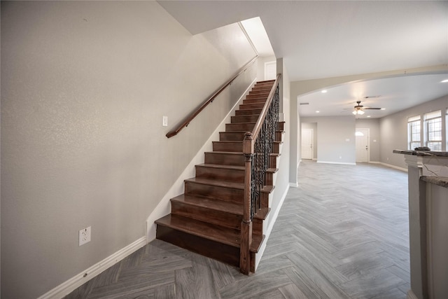 stairs featuring parquet flooring and ceiling fan