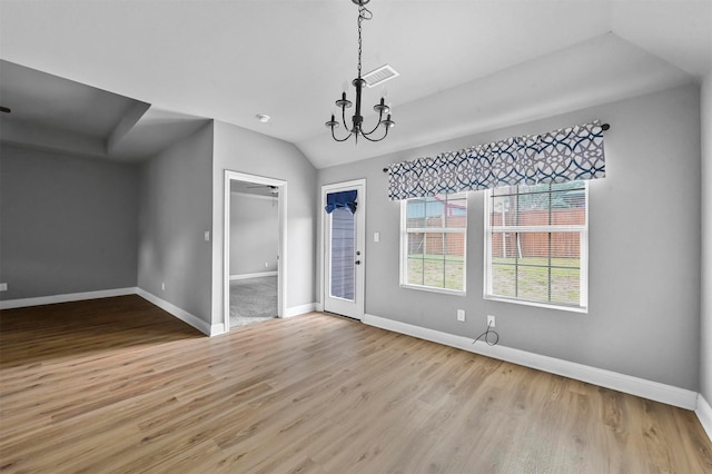 unfurnished dining area with visible vents, baseboards, lofted ceiling, wood finished floors, and an inviting chandelier