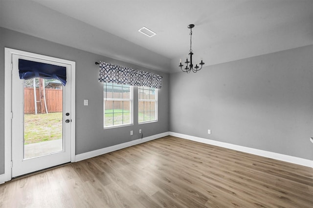 interior space featuring a chandelier, baseboards, and wood finished floors