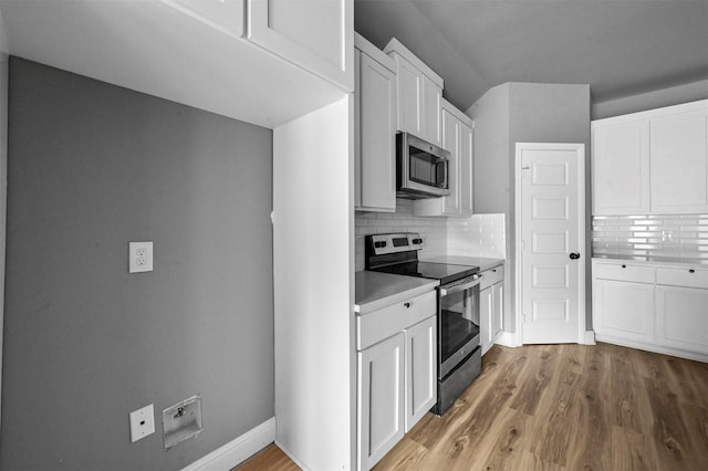 kitchen featuring tasteful backsplash, light wood-style flooring, white cabinetry, and stainless steel appliances