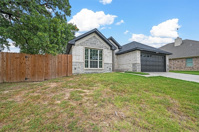 view of front of property with a front yard, concrete driveway, fence, and an attached garage