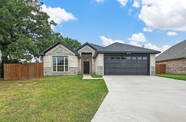 view of front facade featuring a front lawn, fence, driveway, and an attached garage