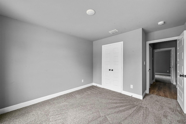 unfurnished bedroom featuring baseboards, visible vents, and carpet flooring