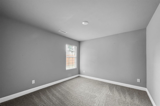 carpeted spare room featuring visible vents and baseboards