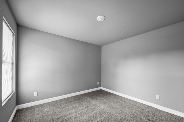 empty room featuring carpet floors and baseboards