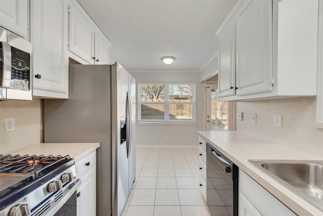 kitchen with light tile patterned flooring, black dishwasher, sink, white cabinets, and ornamental molding