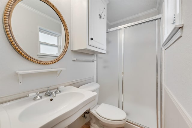 bathroom with toilet, ornamental molding, a shower with door, and sink