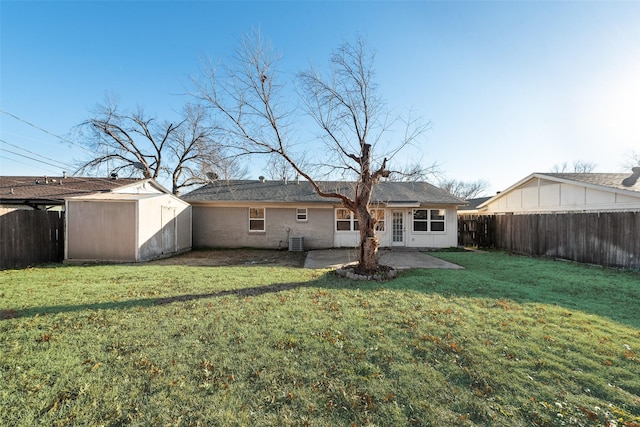 rear view of property with cooling unit, a storage shed, a yard, and a patio area