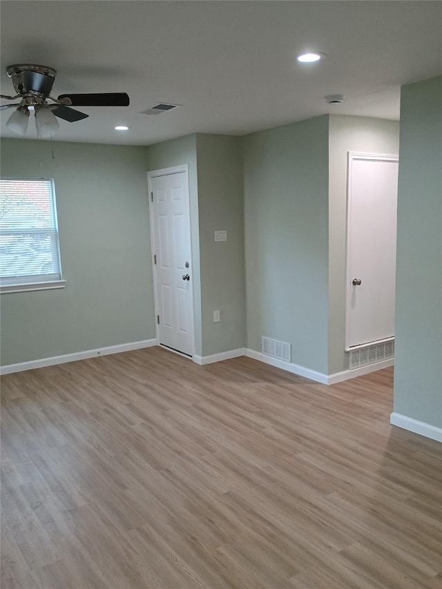 empty room with ceiling fan and light hardwood / wood-style floors