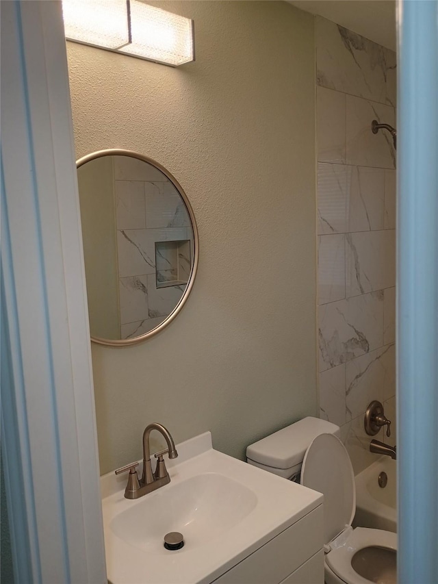 full bathroom with vanity, toilet, and tiled shower / bath combo