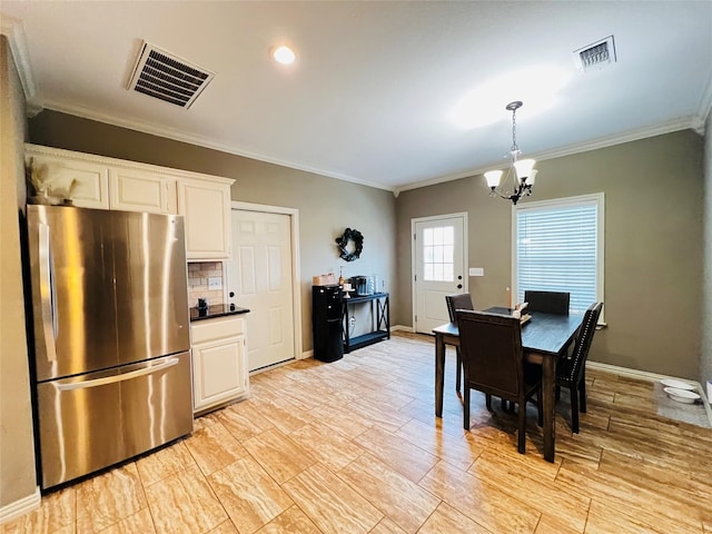 dining area with baseboards, visible vents, a chandelier, and ornamental molding