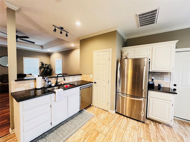 kitchen with white cabinetry, sink, kitchen peninsula, and appliances with stainless steel finishes