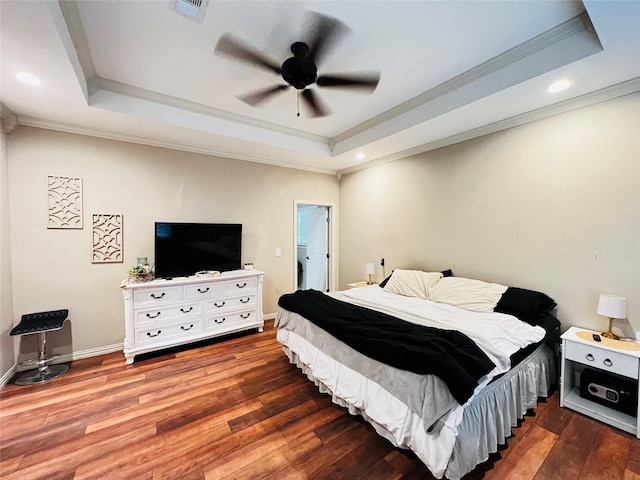 bedroom featuring ornamental molding, wood finished floors, and a raised ceiling