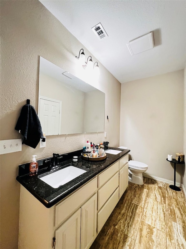 full bathroom with visible vents, a sink, toilet, and wood finished floors