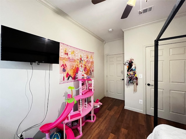 bedroom with ceiling fan, wood finished floors, visible vents, baseboards, and ornamental molding