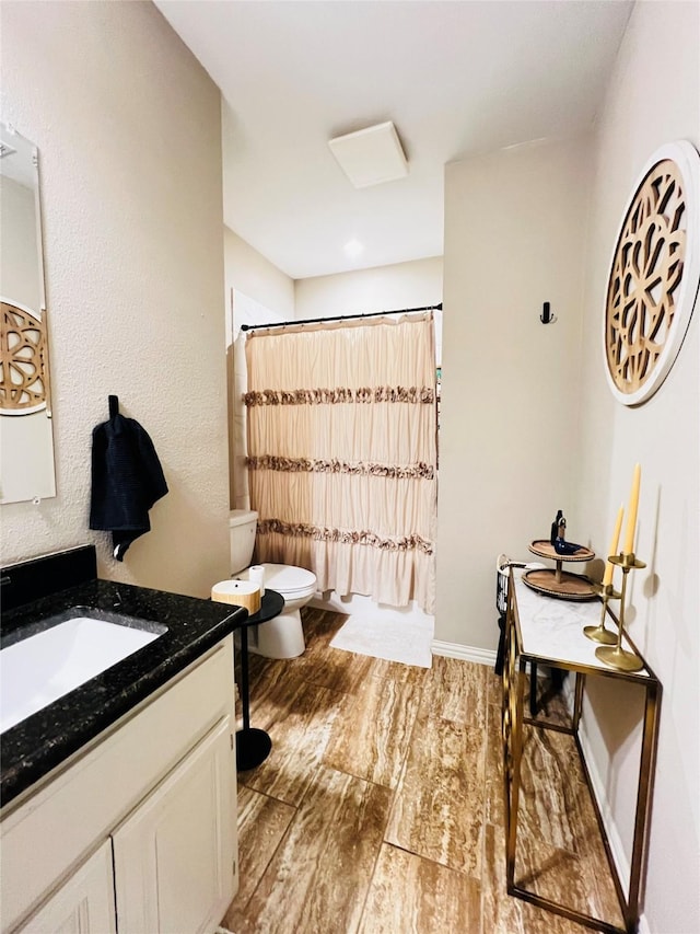 full bathroom with curtained shower, toilet, vanity, wood finished floors, and baseboards