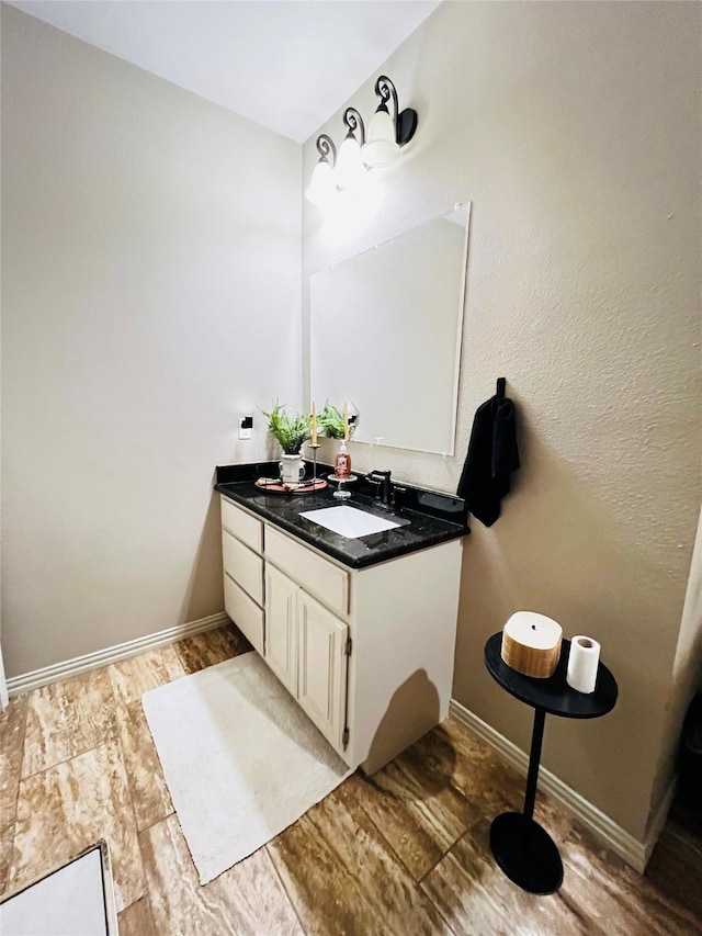 bathroom with vanity, baseboards, and wood finished floors