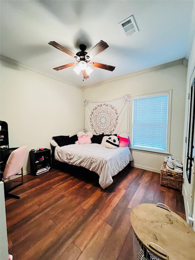 bedroom with crown molding, wood-type flooring, visible vents, ceiling fan, and baseboards