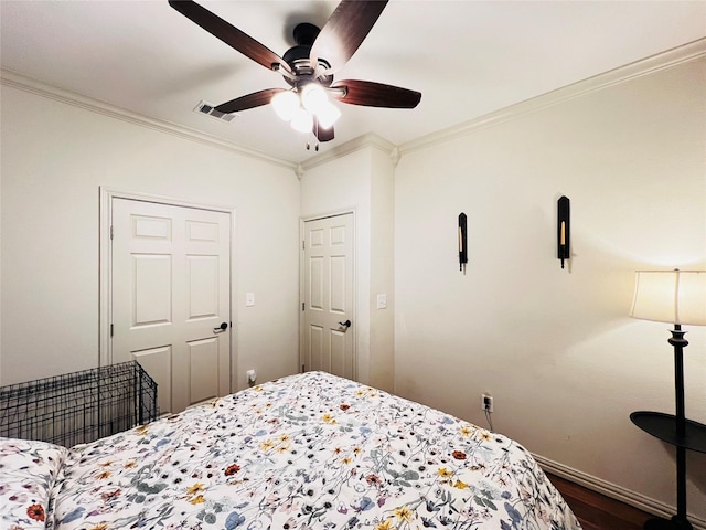 bedroom with visible vents, ornamental molding, a ceiling fan, and wood finished floors