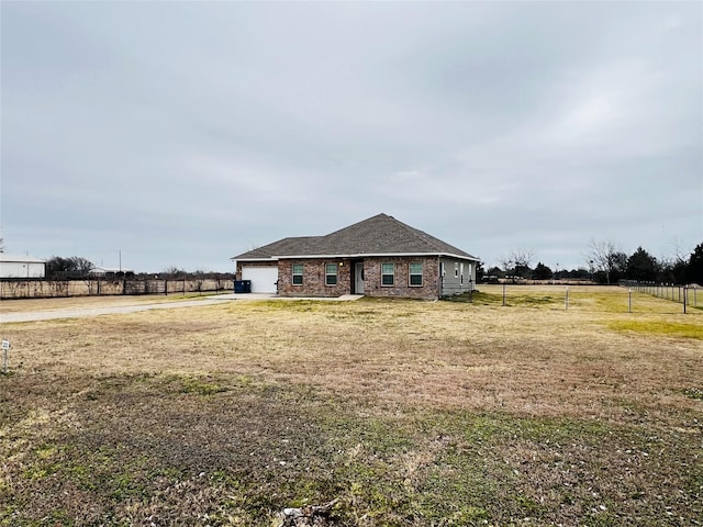 view of front of home featuring a rural view, a garage, and a front lawn