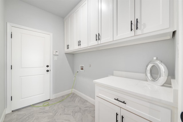 clothes washing area with cabinets and washer hookup