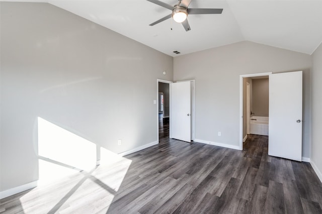 unfurnished bedroom featuring vaulted ceiling, dark hardwood / wood-style floors, ensuite bathroom, and ceiling fan