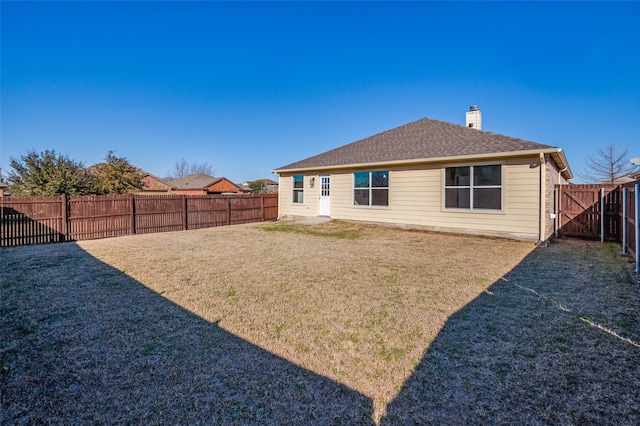 rear view of house featuring a lawn