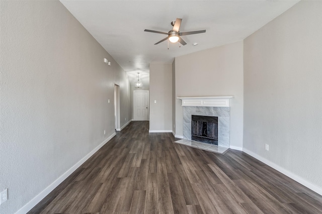 unfurnished living room featuring ceiling fan, a high end fireplace, and dark hardwood / wood-style flooring