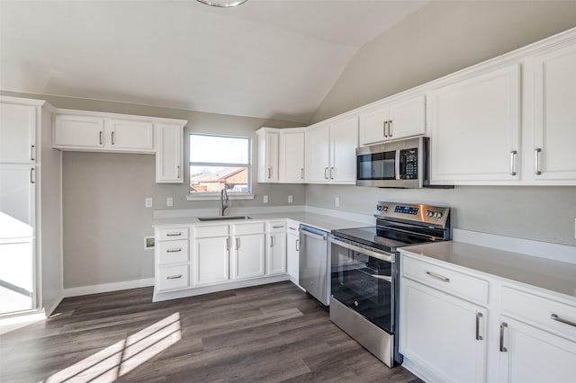 kitchen with stainless steel appliances, white cabinetry, vaulted ceiling, and sink