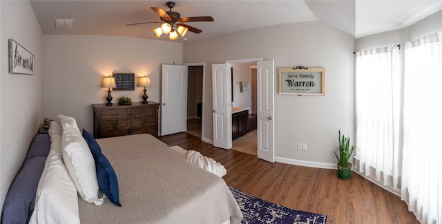 bedroom with ensuite bathroom, lofted ceiling, dark hardwood / wood-style floors, and ceiling fan