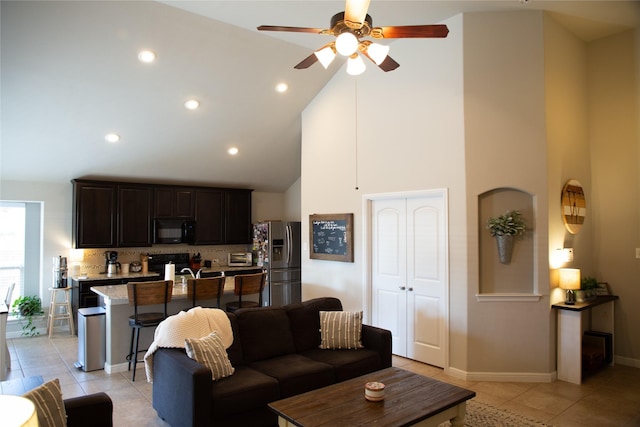 living room featuring light tile patterned floors, high vaulted ceiling, and ceiling fan