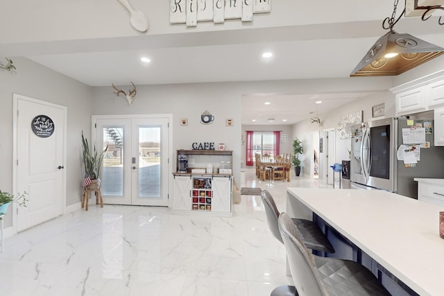 kitchen with french doors, marble finish floor, recessed lighting, white cabinetry, and stainless steel fridge