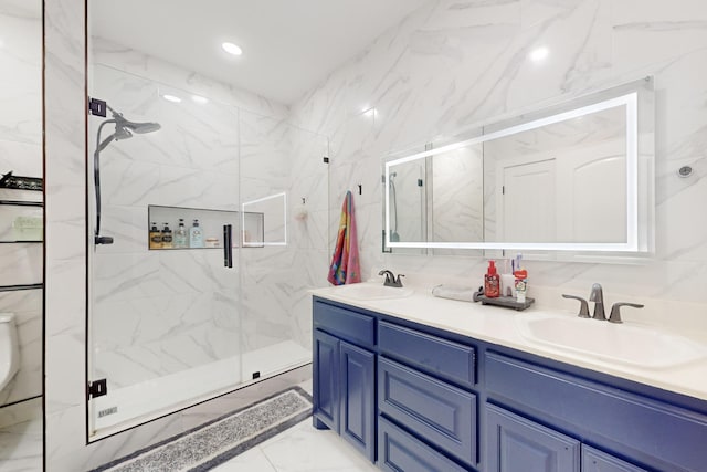 full bathroom with marble finish floor, double vanity, a sink, and a marble finish shower